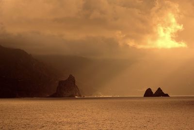 Scenic view of sea and mountains against sky during sunset