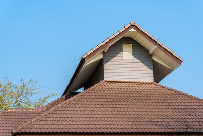 Low angle view of building roof against clear sky