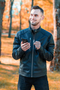 Portrait of smiling young man using mobile phone