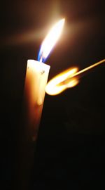 Close-up of lit candle in dark room