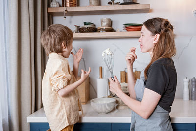 Family fun in the kitchen. mother and son baking carrot cake together. scandinavian kitchen interior