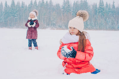 Full length of girl standing on snow covered field