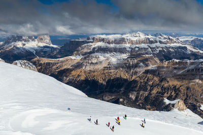 People on snowcapped mountains against sky