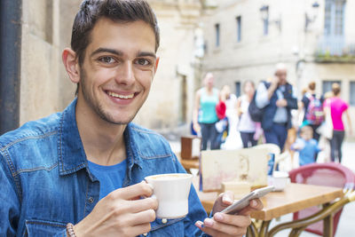 Young man drinking coffee on the terrace