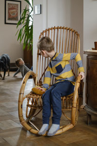 Child in rocking chair in vintage house. retro home for family. boy kid resting in armchair