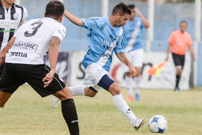 Men playing soccer on field