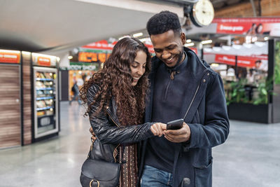 Young couple looking at camera while standing on bus