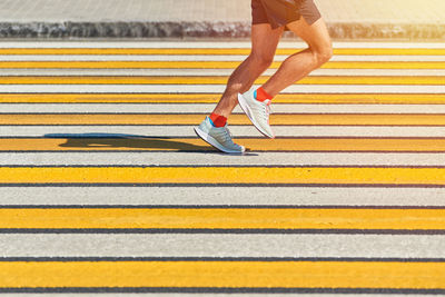 Man running crosswalk, copy space. athletic man jogging in sportswear on city road. street sprinting