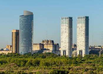 Modern buildings in city against clear sky