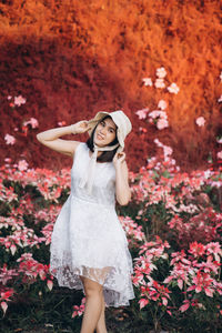 Portrait of smiling woman standing against plants