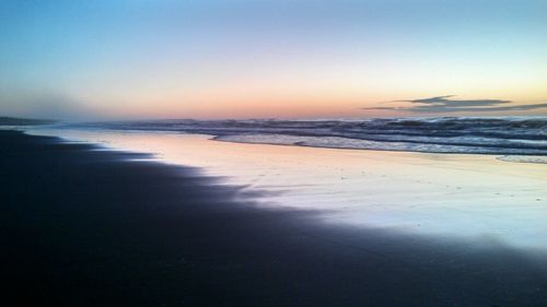 Scenic view of beach against sky during sunset