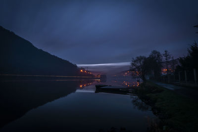 Bridge over river against sky at night