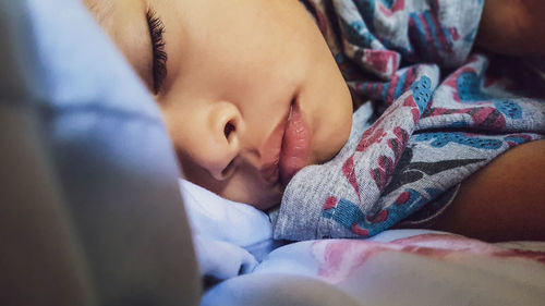 Close-up of baby sleeping on bed