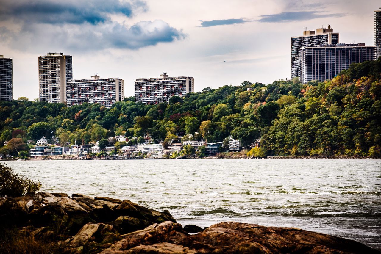 skyscraper, architecture, city, building exterior, cityscape, built structure, modern, river, tower, growth, urban skyline, development, skyline, sky, city life, water, downtown district, outdoors, tall, no people, tree, urban scene, high, nature, residential, day