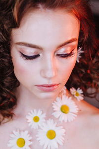 Close-up of beautiful young woman wearing flowers and make-up