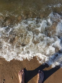 Low section of person standing on beach