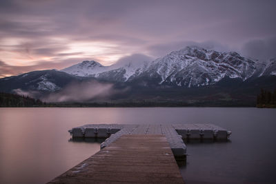 Scenic view of lake and snowcapped mountains against sky during winter