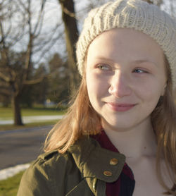 Close-up of smiling girl wearing knit hat in park