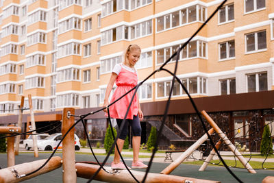 Woman standing by building in city