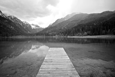 Scenic view of lake by mountains against sky