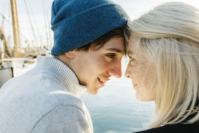 Smiling young couple face to face at harbor