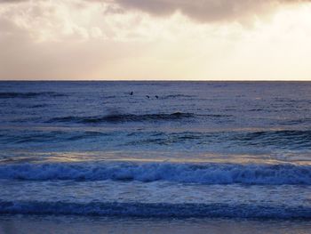 Scenic view of beach against cloudy sky