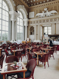 Empty chairs and tables in cafe against building