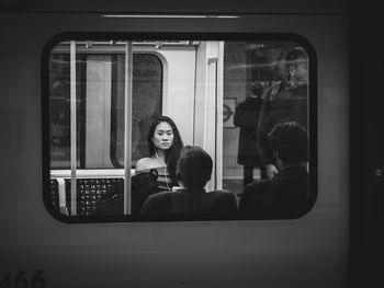 Full length of young woman sitting in train