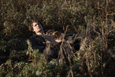 Portrait of man lying down on plants