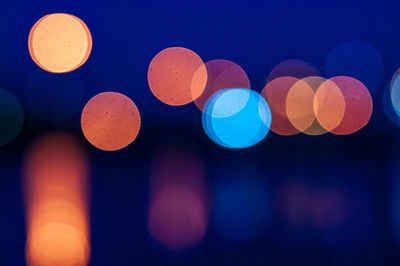 Defocused image of lights against sky at night
