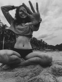 Portrait of smiling young woman lying on land against sky