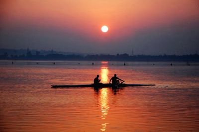 Silhouette boat in sea against sky during sunset