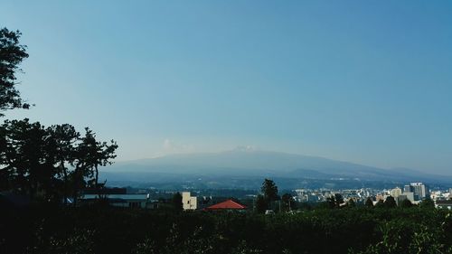 Houses in town against clear blue sky