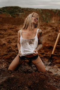 Young women in a dirty tank top in clay