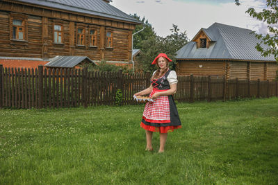 Full length of young woman standing on field