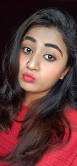 Close-up portrait of a beautiful young woman over black background