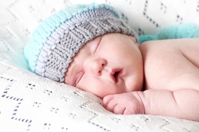 Close-up of baby sleeping on bed