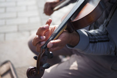 Midsection of man playing guitar
