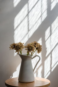 Close-up of flower vase on table against window