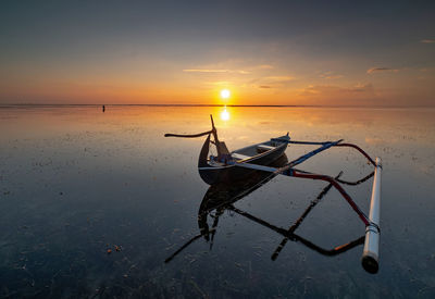 View of ship on beach against sky during sunset