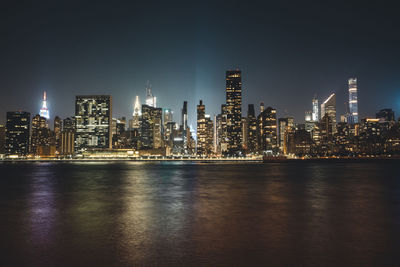 Illuminated buildings against sky at night