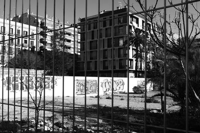 View of buildings through chainlink fence