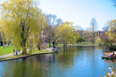 People on riverbank against sky