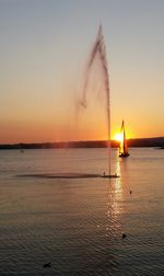Sailboat in sea at sunset