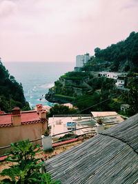 High angle view of houses by sea against sky