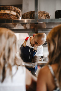 Rear view of people standing in kitchen