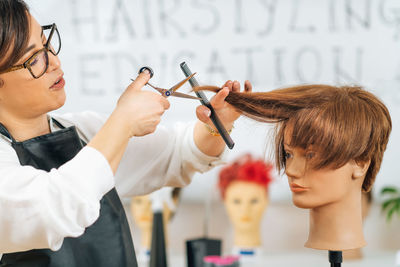 Haircutting education - hairstylist explaining haircutting techniques to students