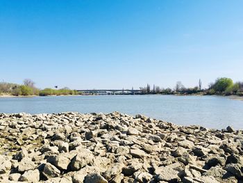 Scenic view of river against clear blue sky