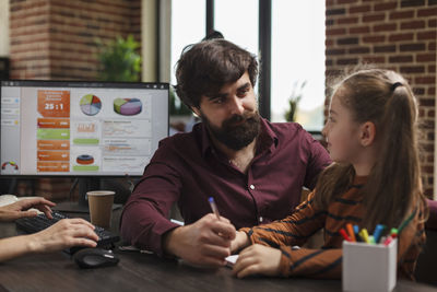 Businessman talking with girl at office