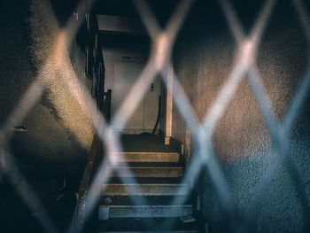 Blurred motion of train seen through chainlink fence